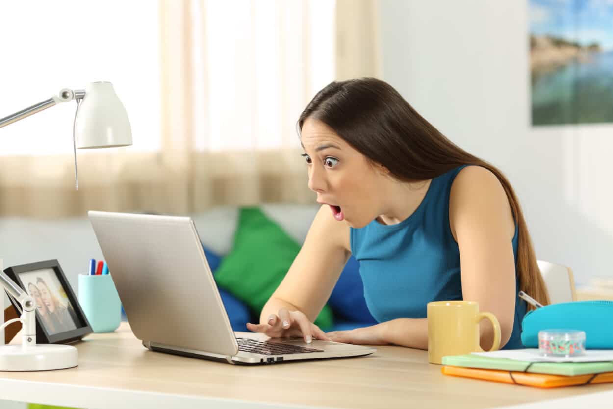 Surprised woman checking her laptop