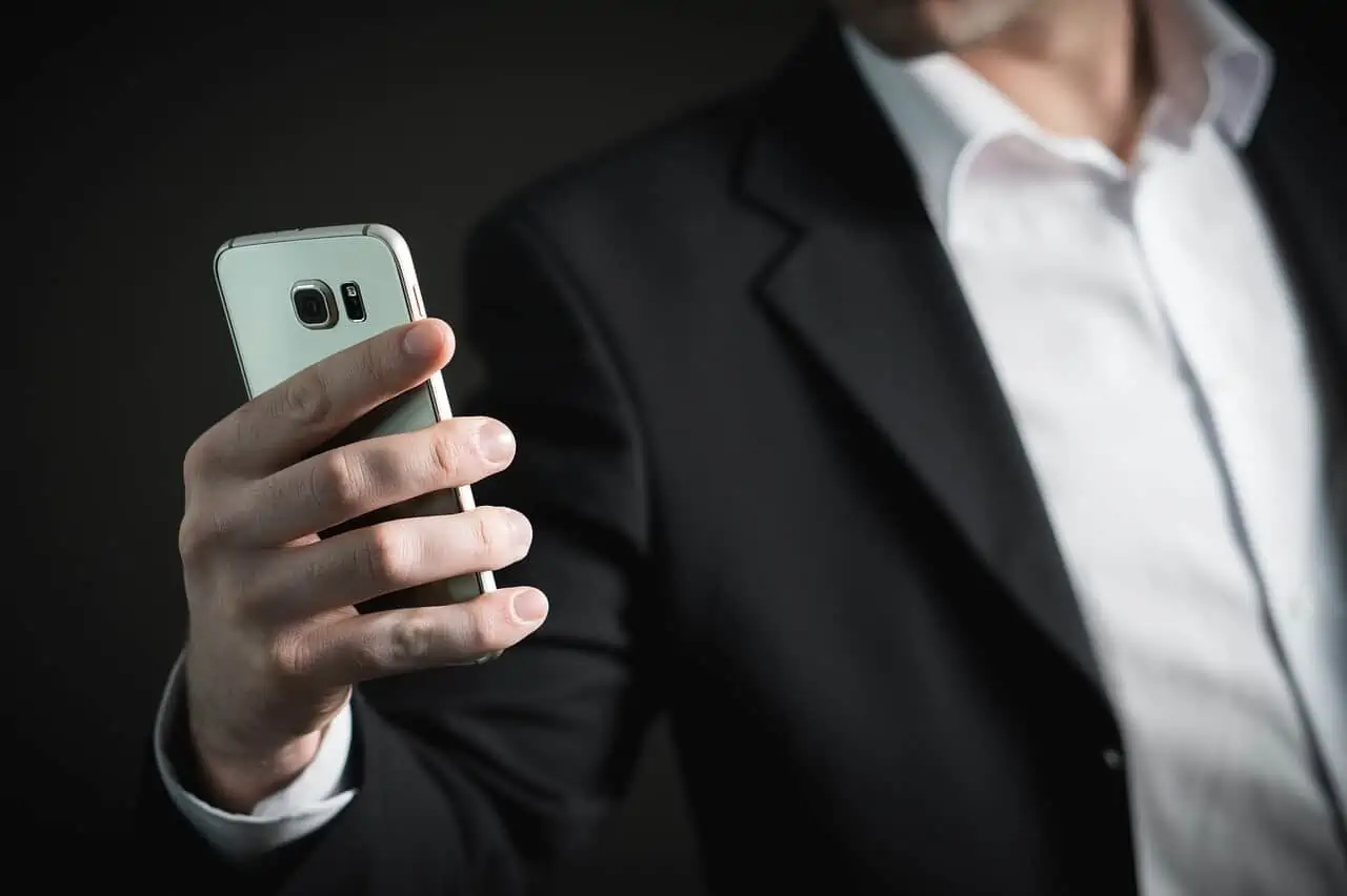 A man in a suit holding a cell phone