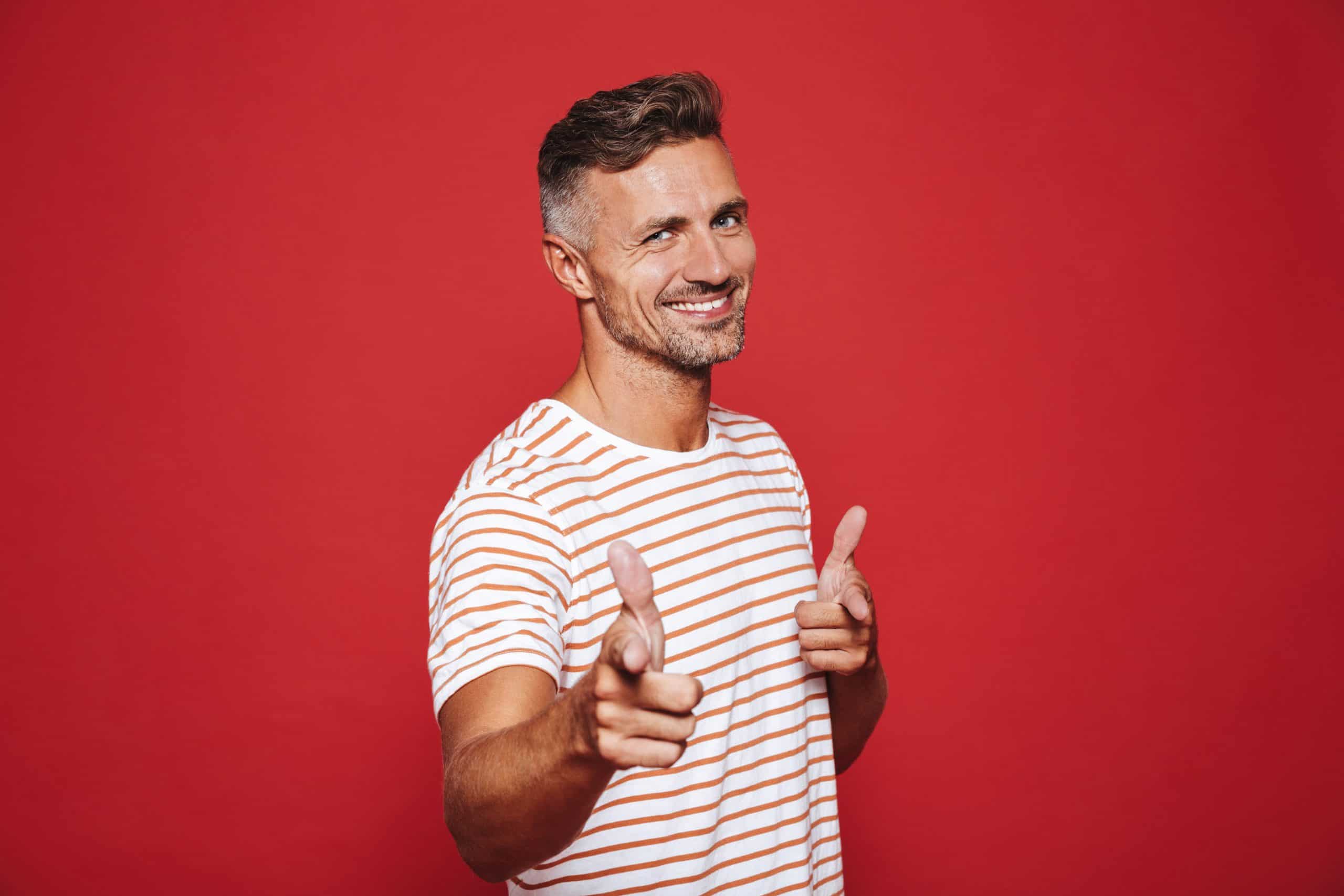 A man giving a thumbs up with a red background