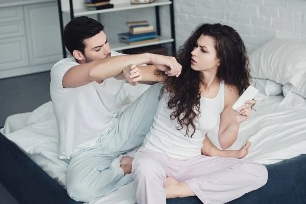 Couple Fighting In Bed Woman Holding Her Phone