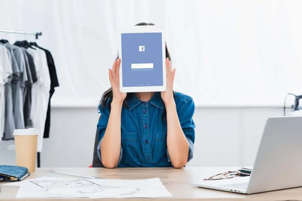 Woman Holding A Tablet With Facebook Page Showing