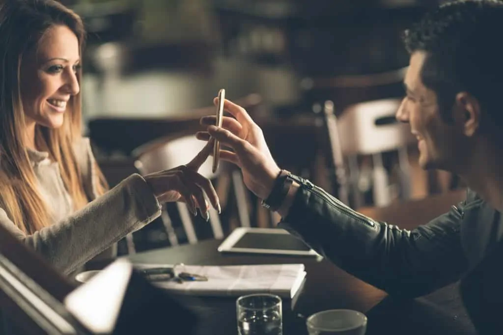 Man Showing Something On His Phone His Date