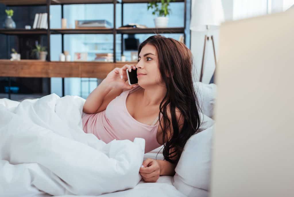 Woman In Bed Talking On Cellphone