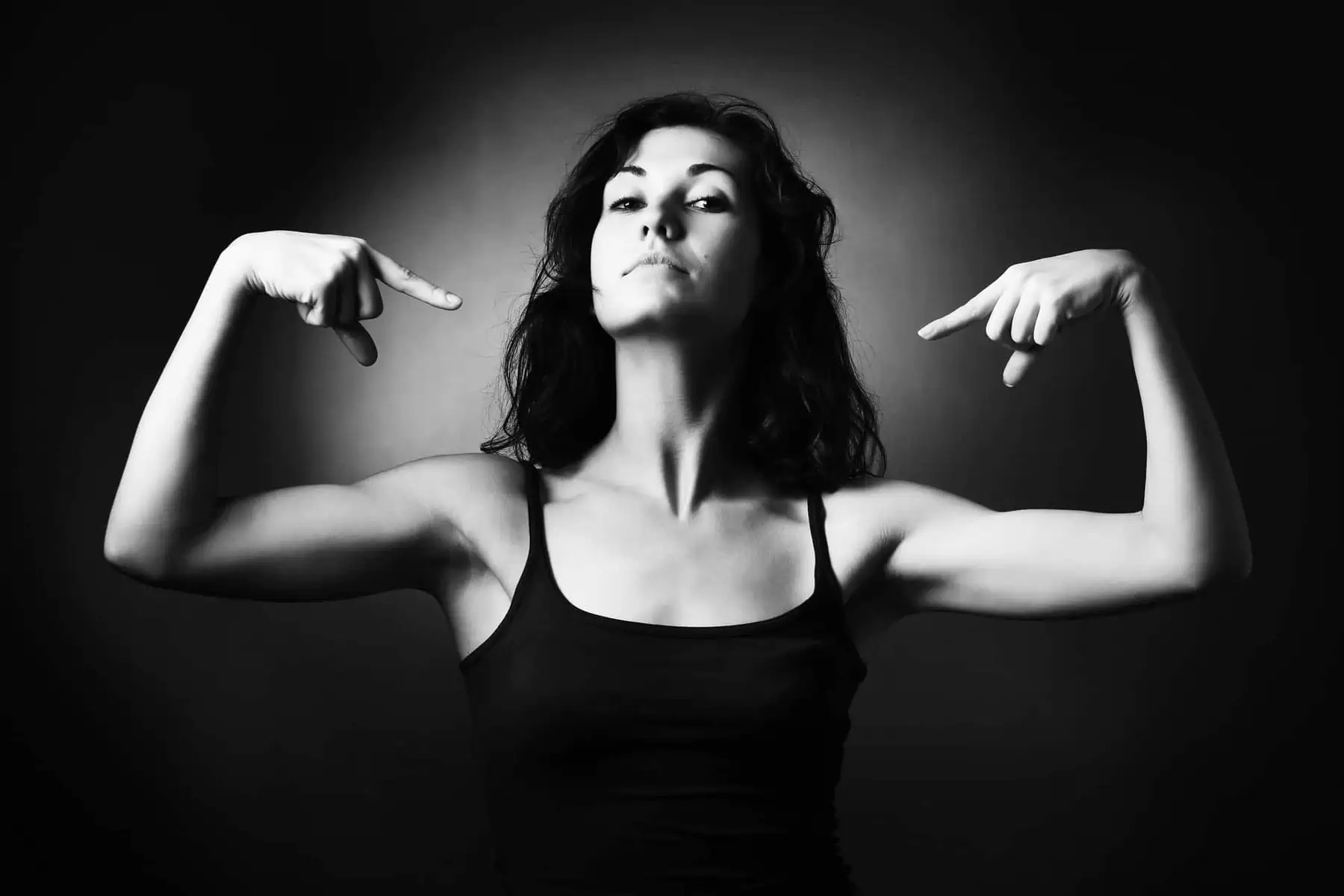 A woman in a black tank top posing for a picture