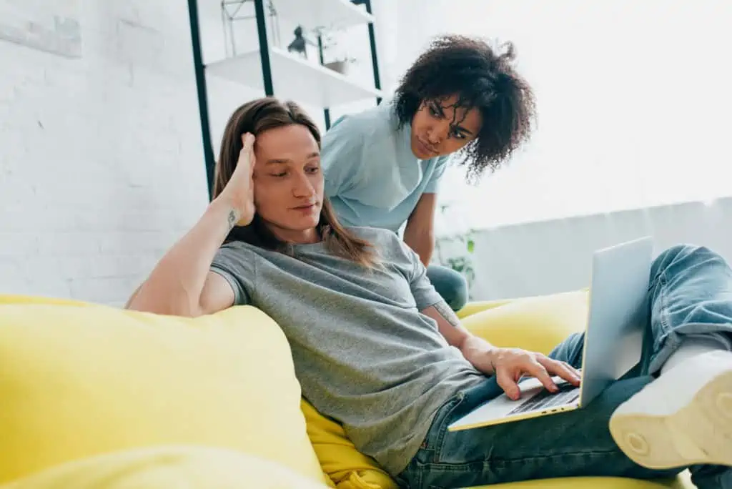 Man Using His Laptop While Girlfriend Looks On