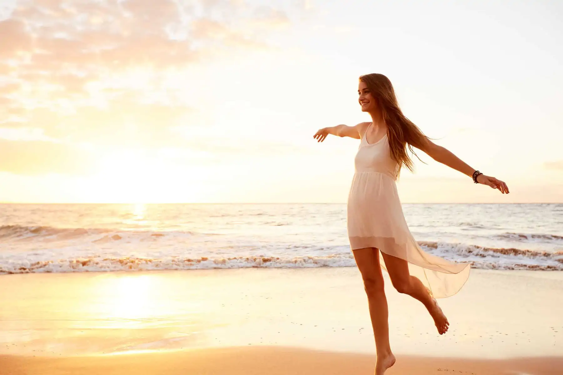 A woman in a white dress on a beach