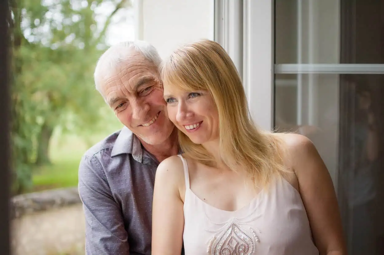 Old and young couple by the window