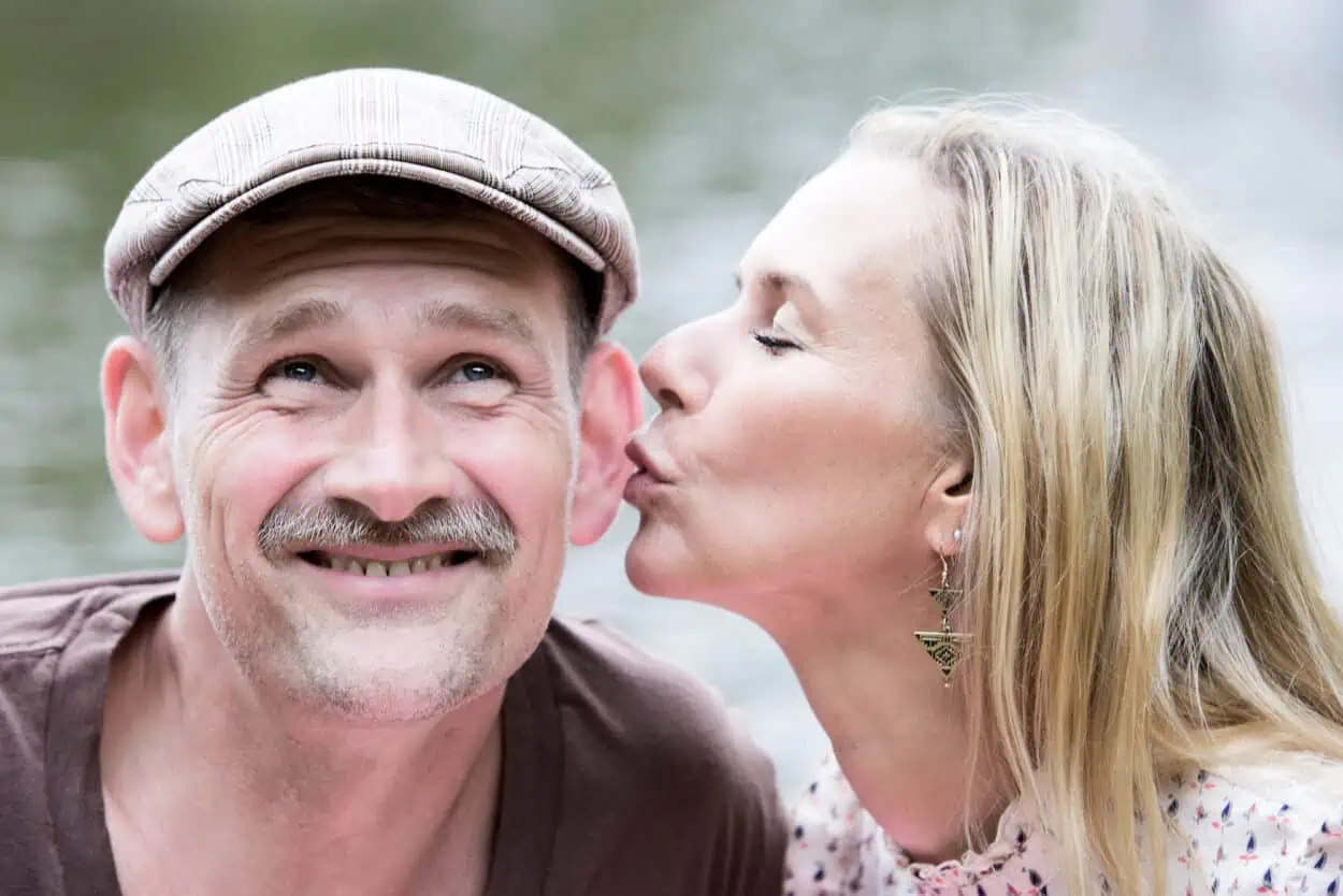 Younger woman kissing an older guy