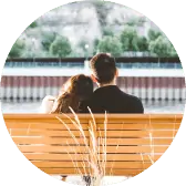A man and a woman sitting on a wooden bench