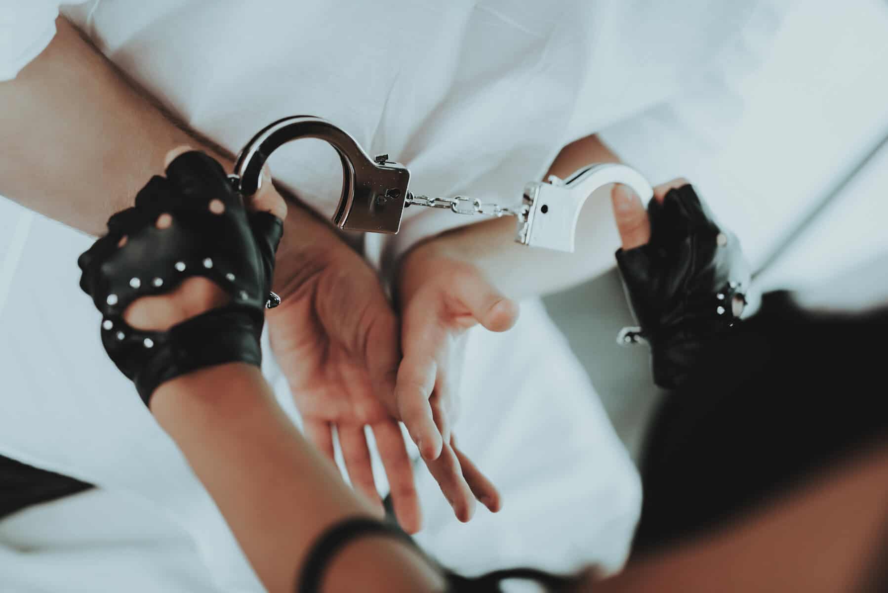 A person holding a pair of handcuffs in their hands