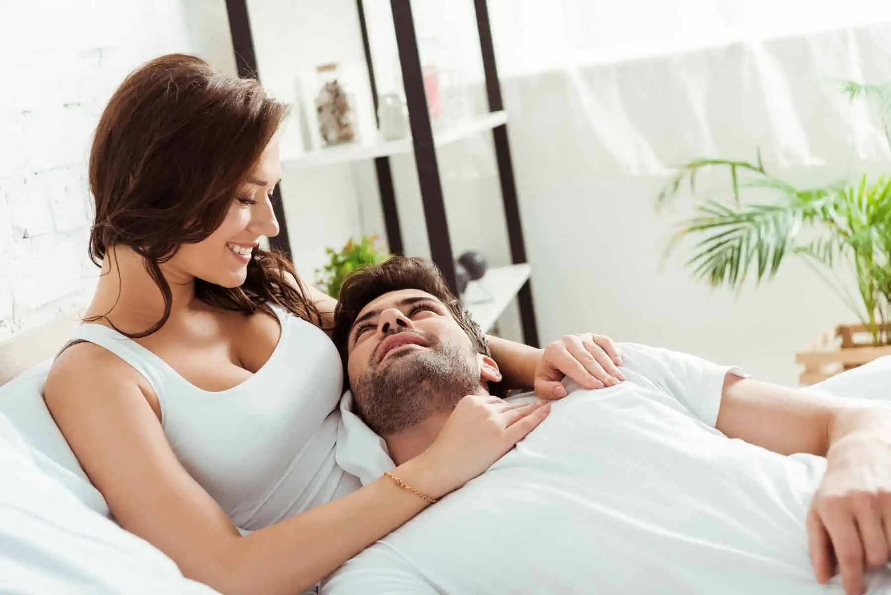 A man laying in bed next to a woman