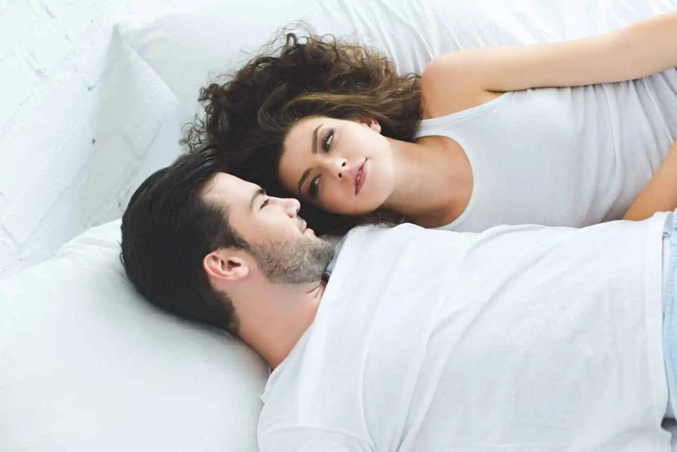 A man and a woman laying on a bed together