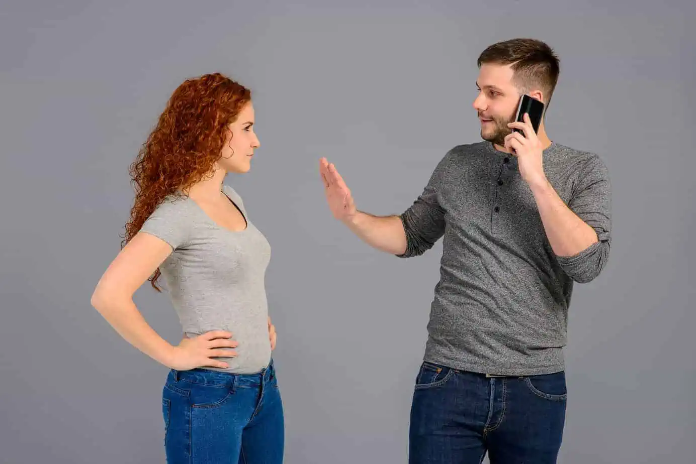 A man standing next to a woman talking on a cell phone
