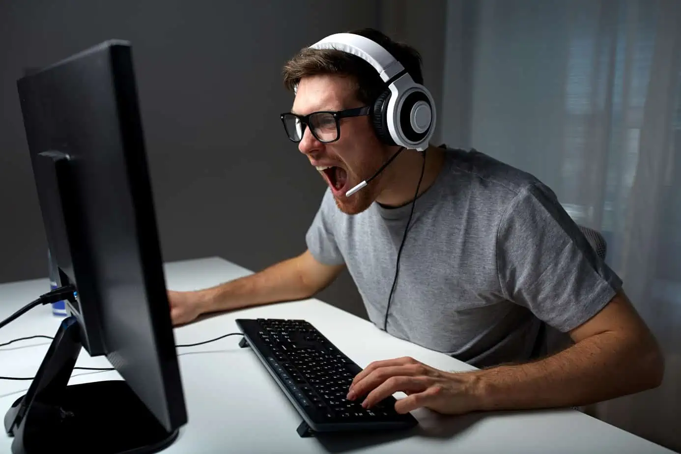 A man wearing headphones and using a computer