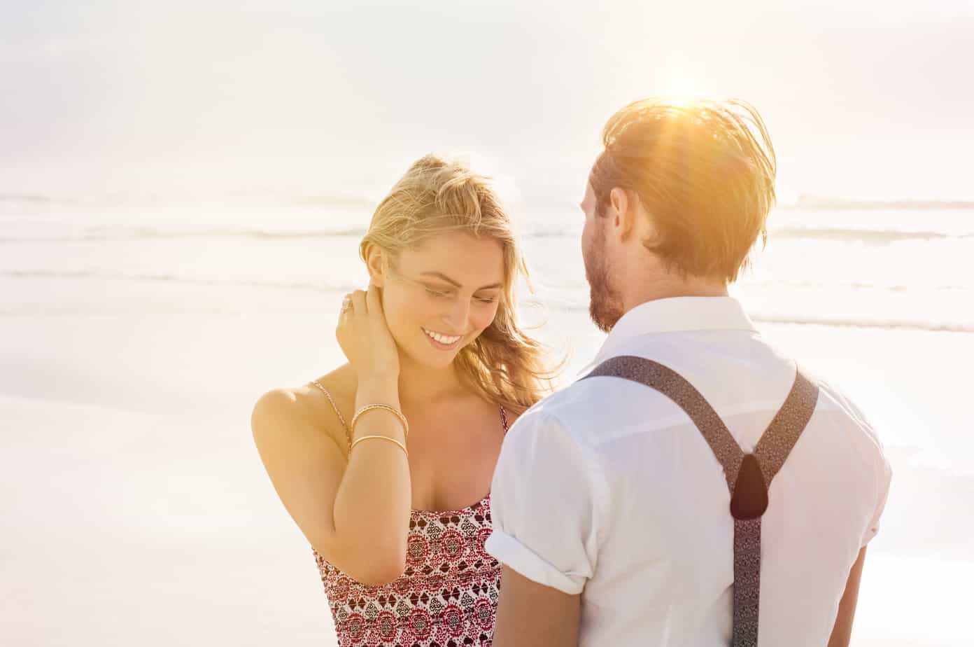 A man standing next to a woman on a beach