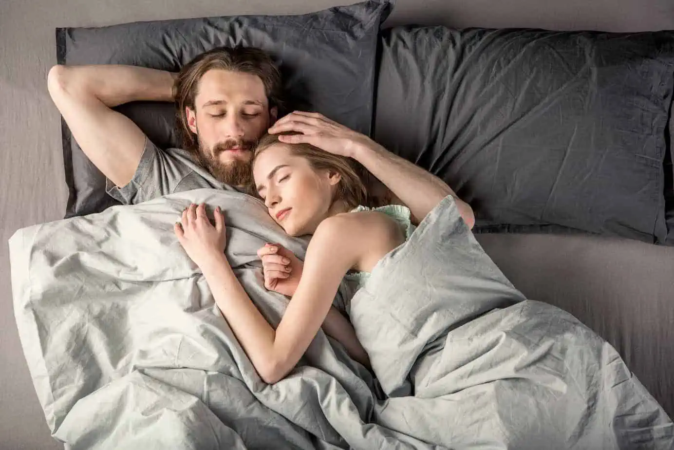 A man and a woman laying in bed together