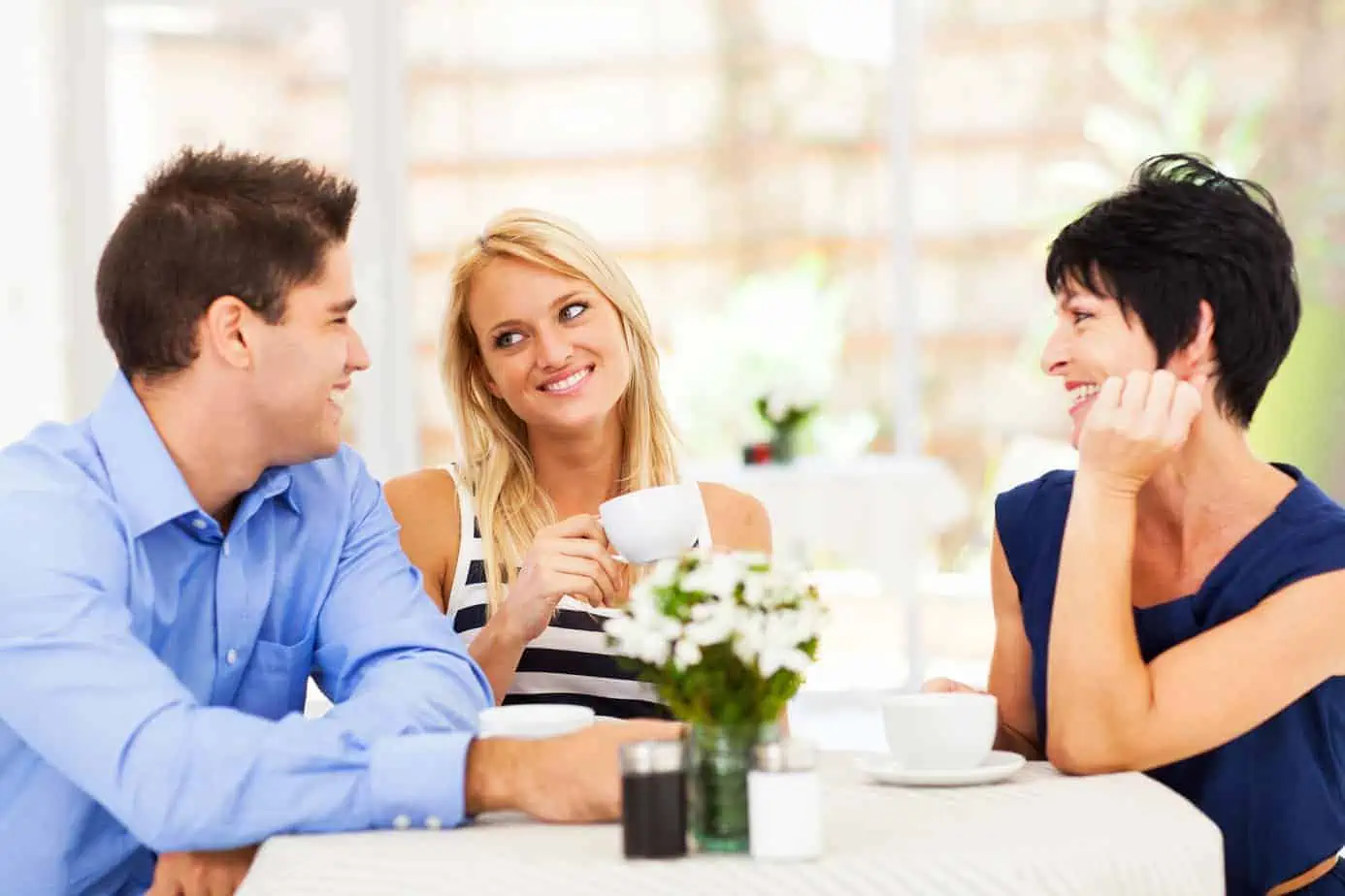 Three people sitting at a table having a conversation
