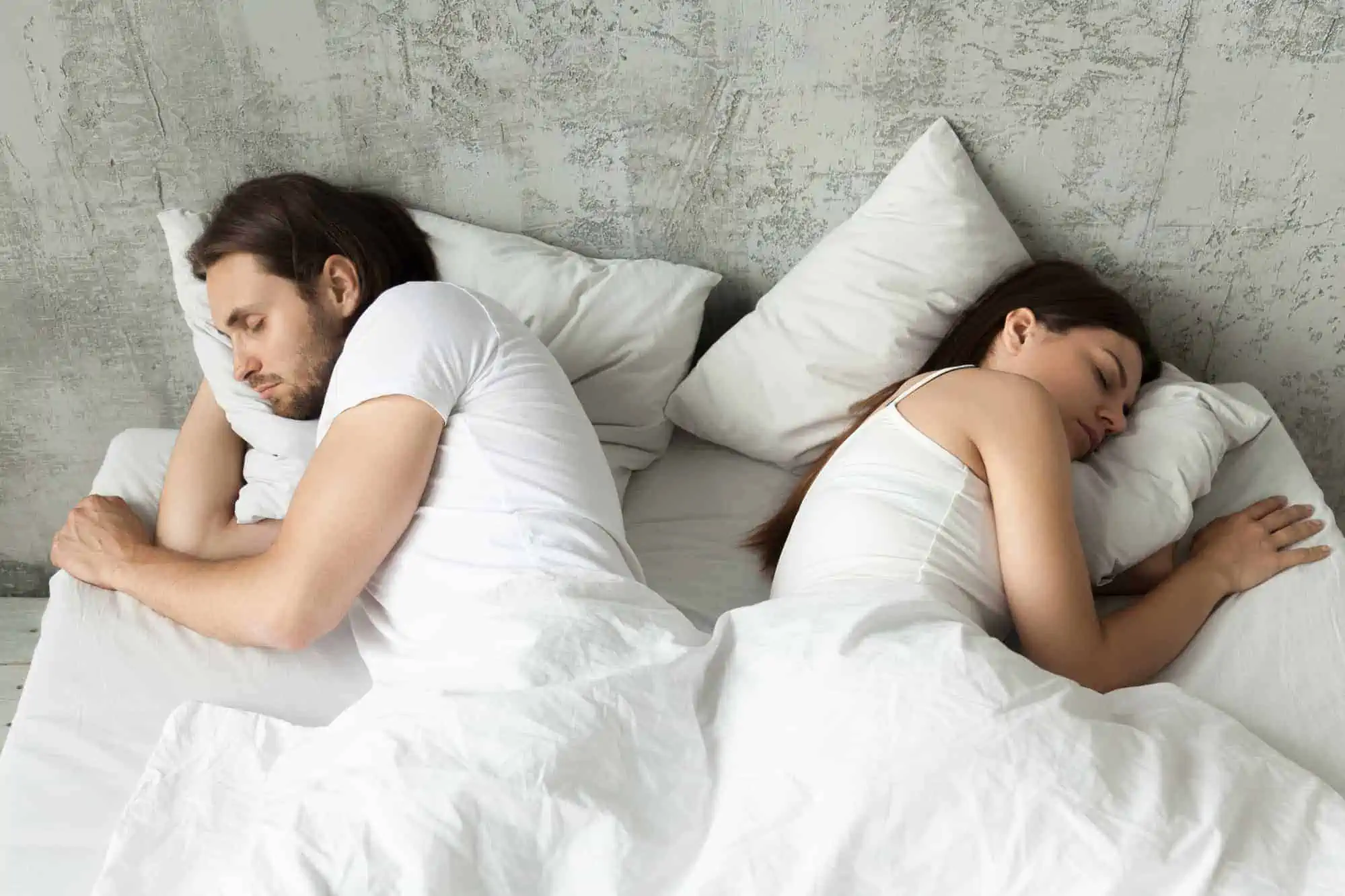 A man and a woman sleeping in bed