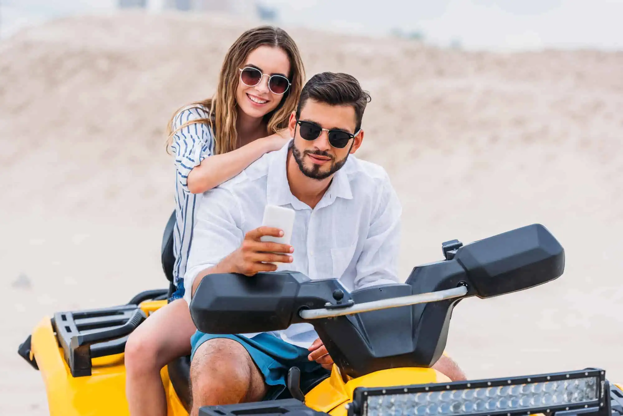 A man and a woman on a yellow atv