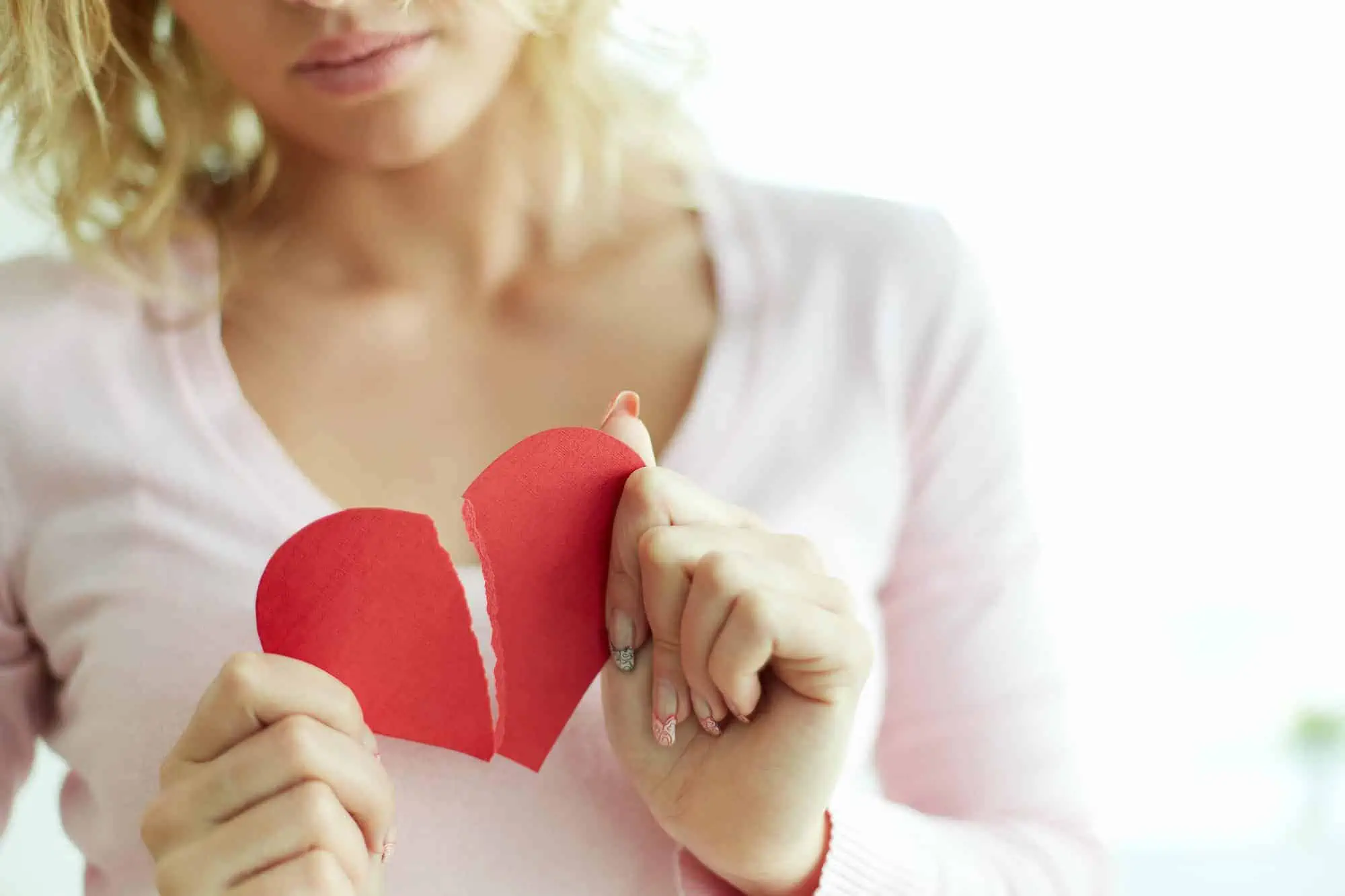 A woman holding a heart shaped piece of paper
