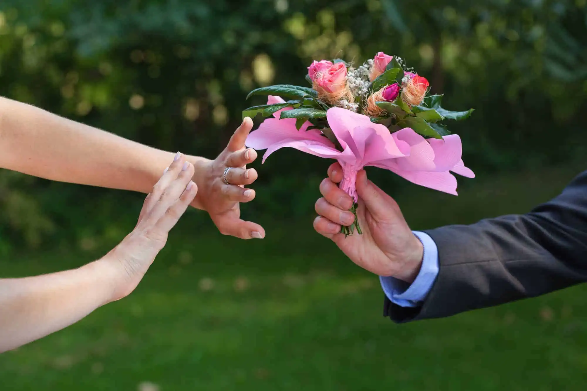 A couple of people holding a bouquet of flowers