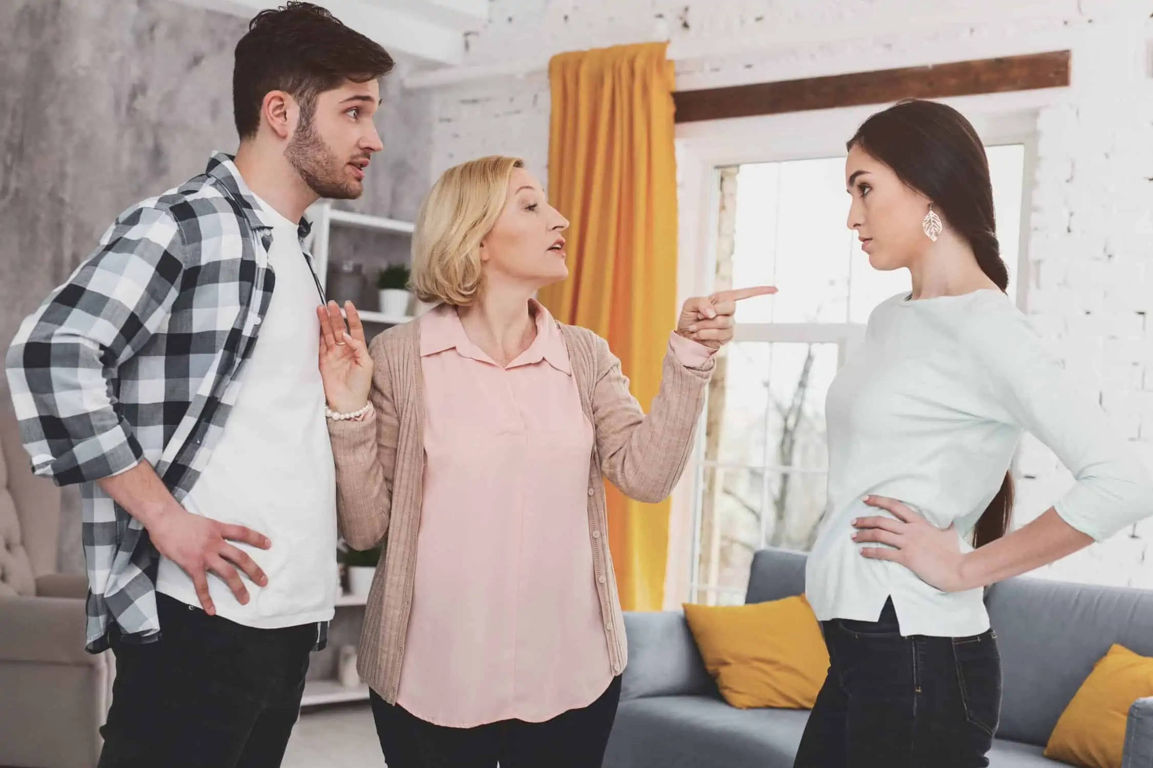 A man and two women standing in a living room