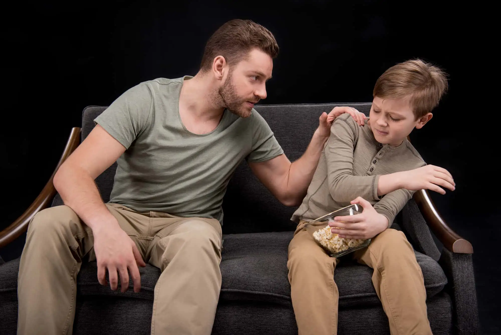 A man sitting next to a boy on a couch