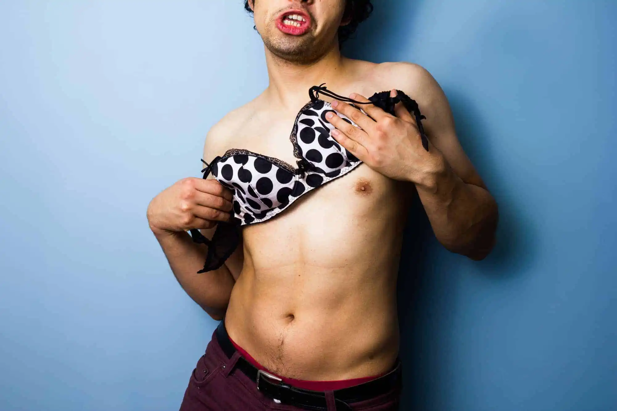 A shirtless man with a polka dot bra