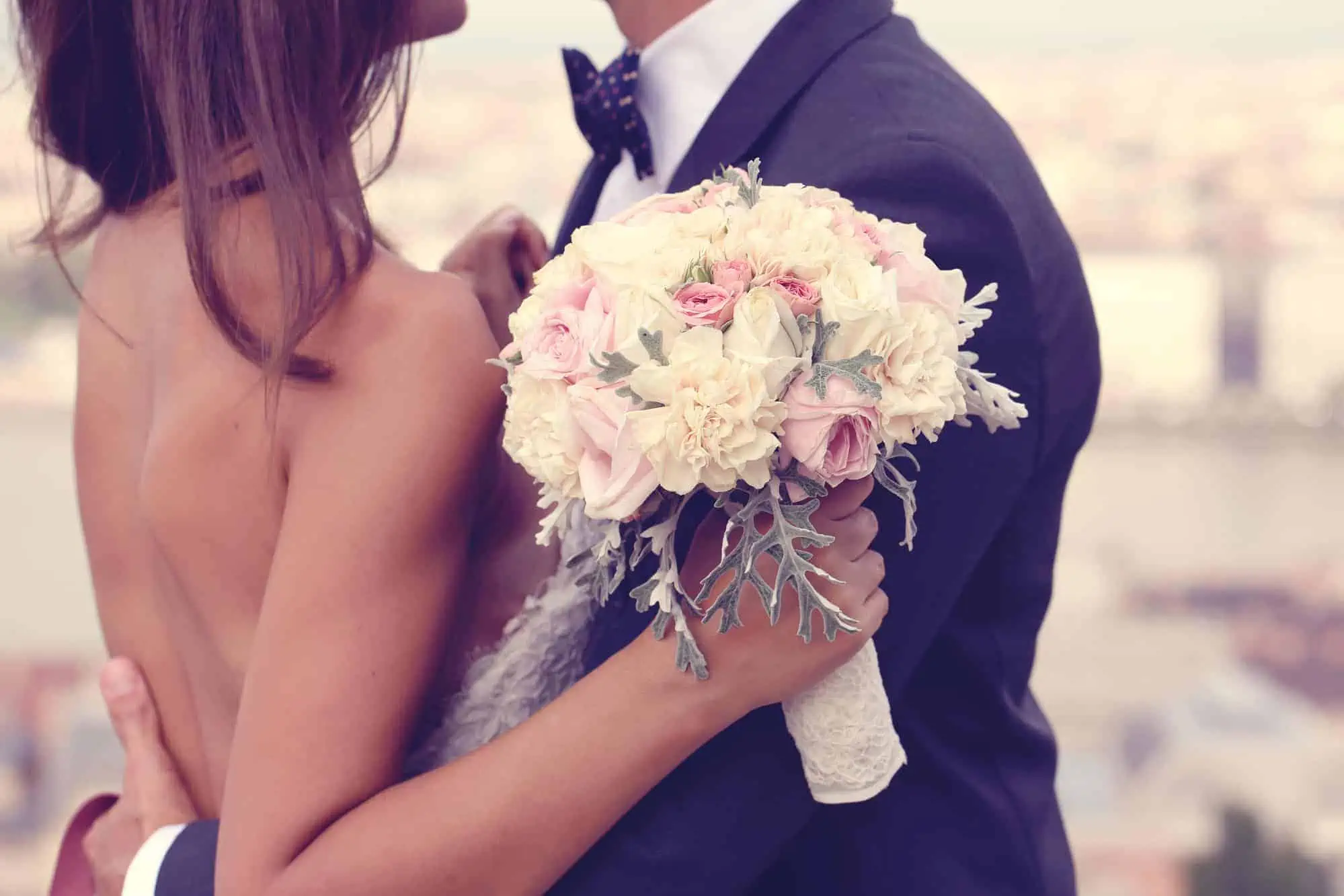 A man and a woman holding a bouquet of flowers