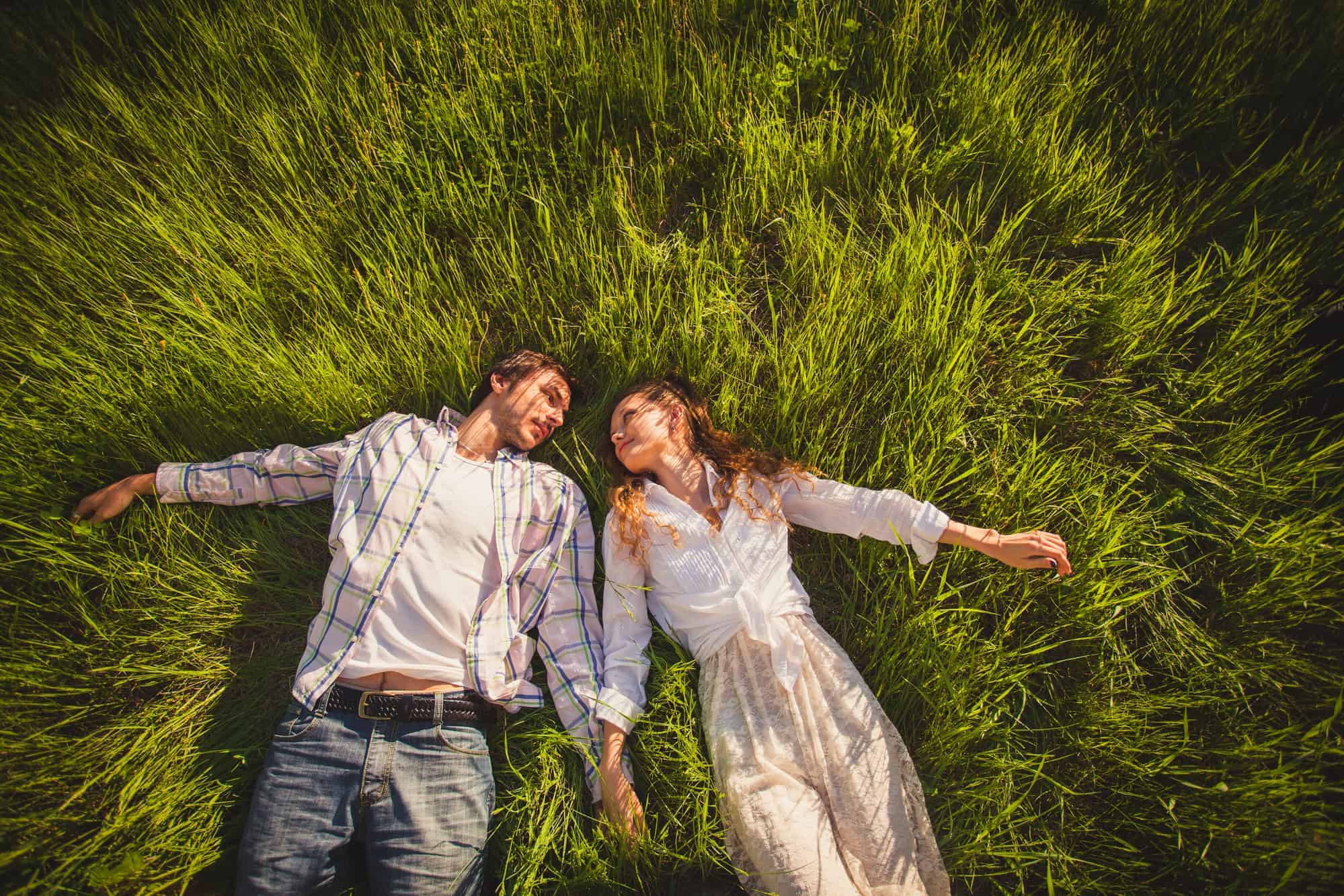 A man and a woman laying in the grass