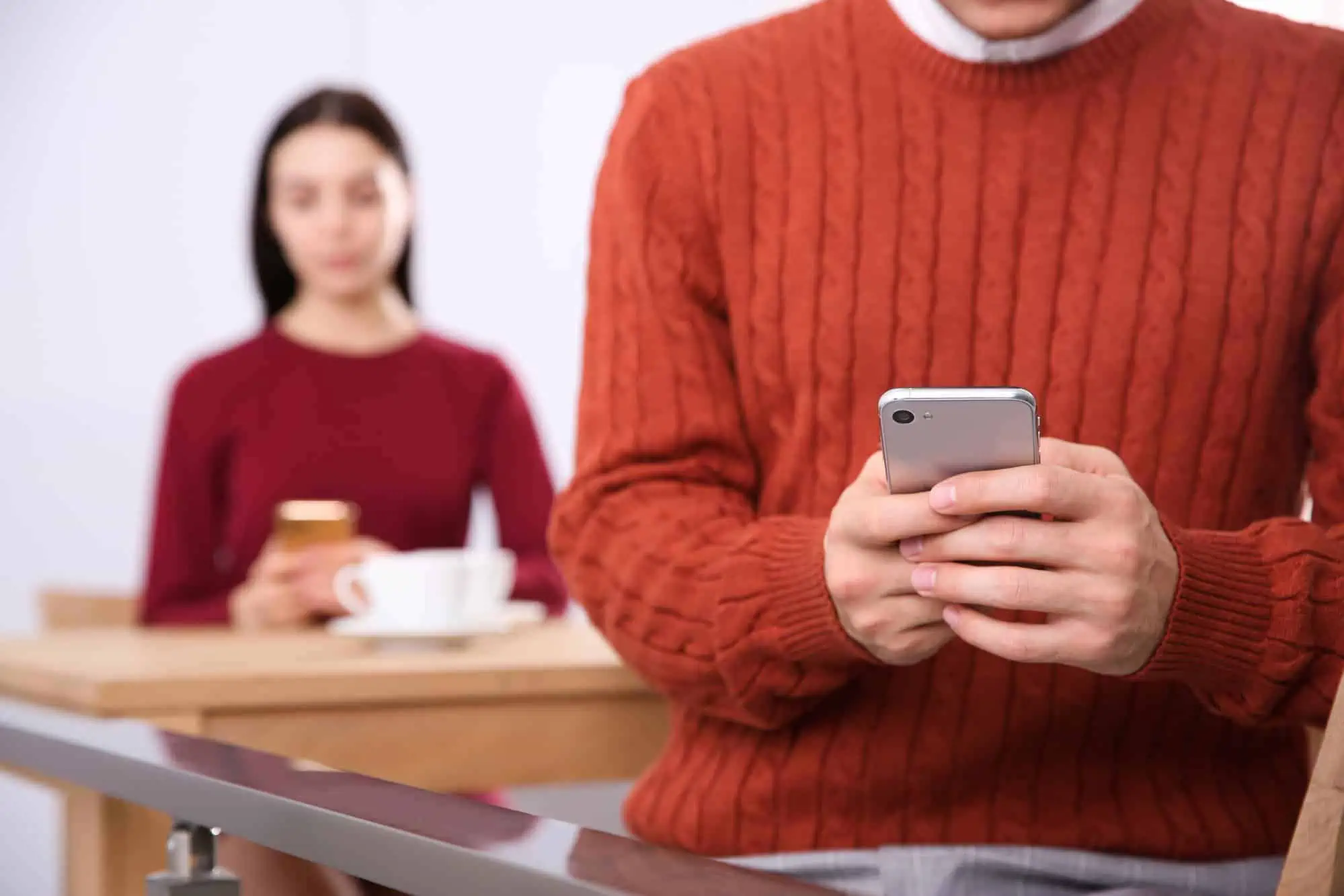A man in a red sweater holding a cell phone