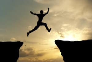 Man jumping from one cliff to another