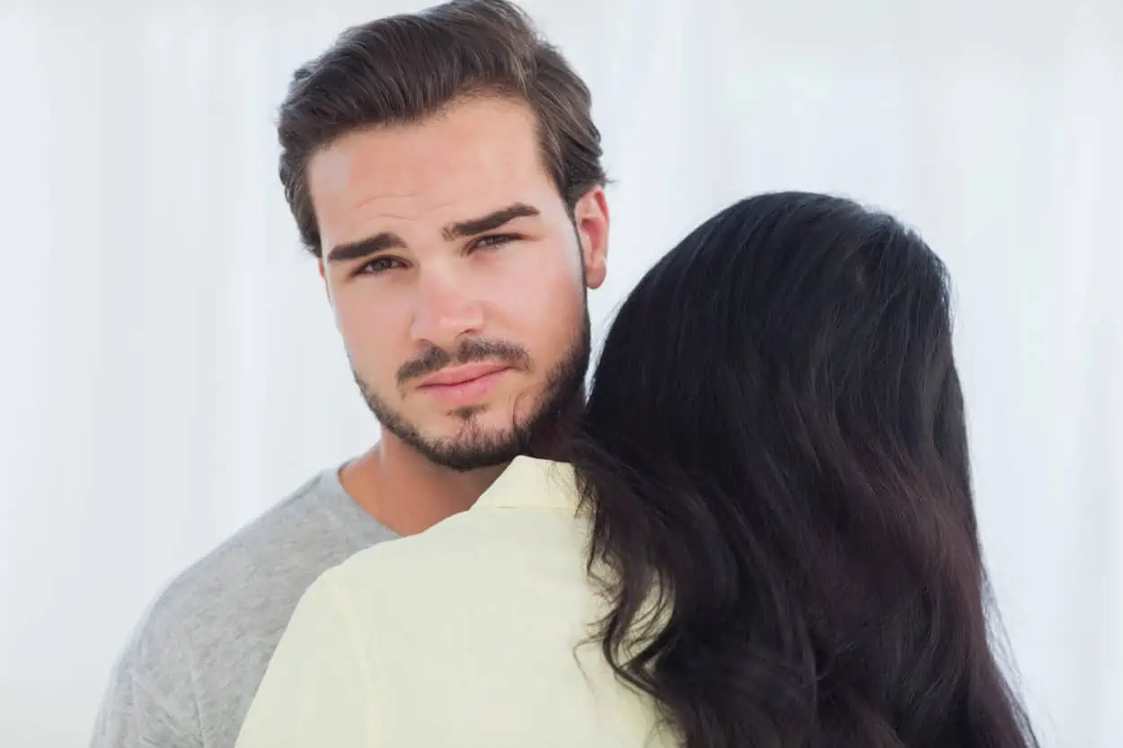 Woman hugging, man looking uncomfortable